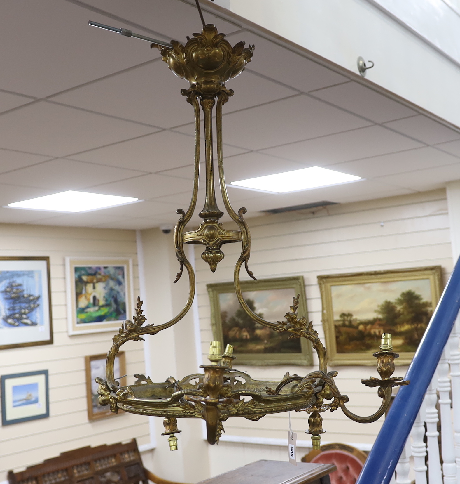 A gilt metal five branch chandelier, decorated with masks, 78cm high